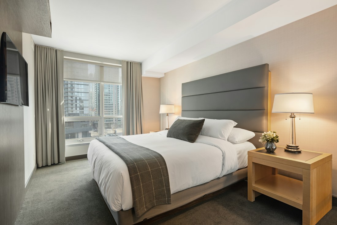 A contemporary bedroom with an inviting bed and warm wood details